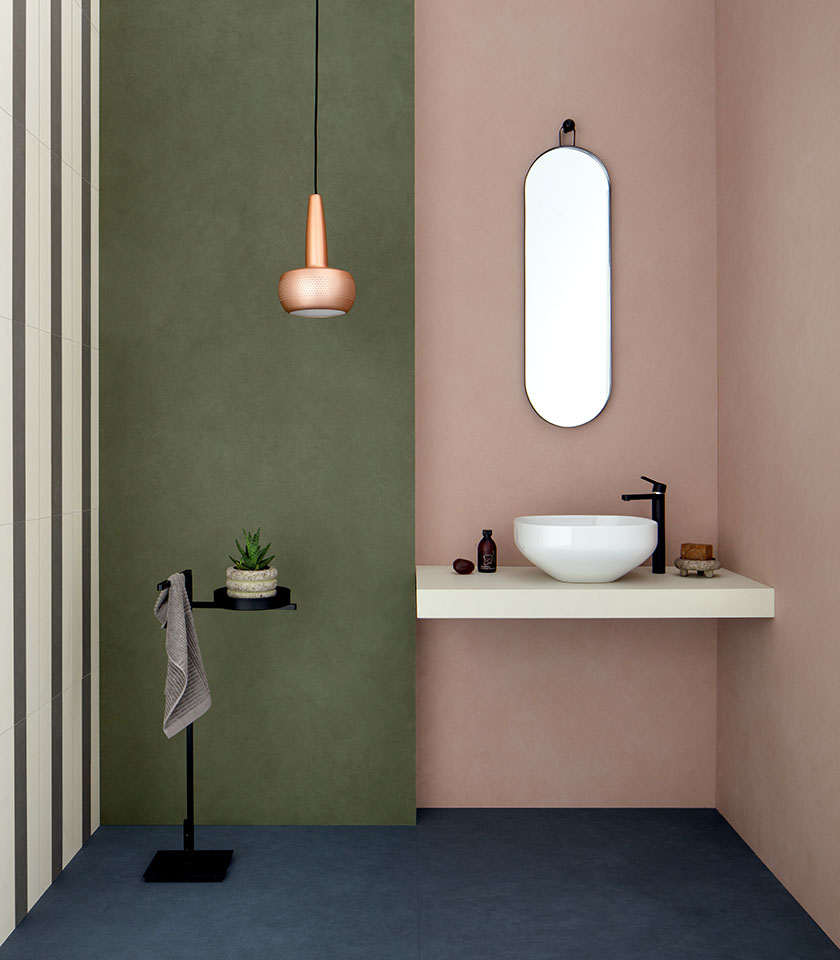 Modern bathroom with green and pink walls, clean surfaces and minimalist design details.