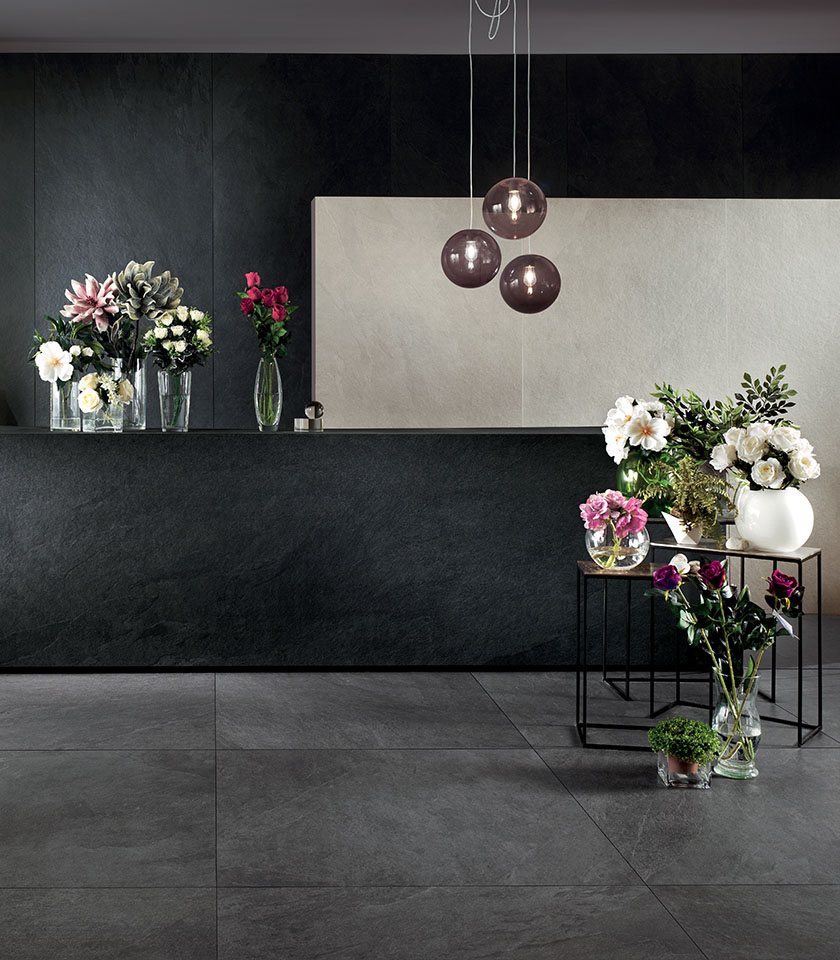 Contemporary space with flooring and wall coverings from the Waterfall collection in stone effect, in the Gray Flow, Dark Flow and Ivory Flow shades.
