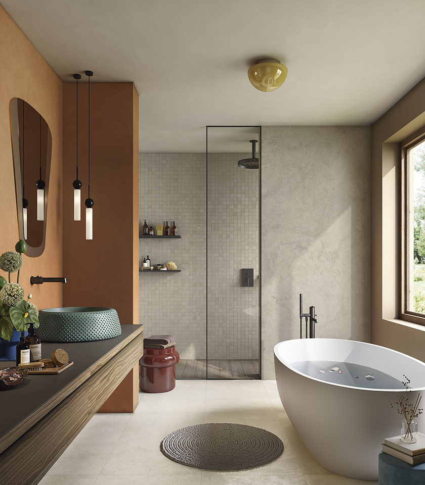 Pulse Shell and Clay define a bright, tactile bathroom, where stone-effect ceramic surfaces, mosaics and warm tones create a natural and contemporary atmosphere.