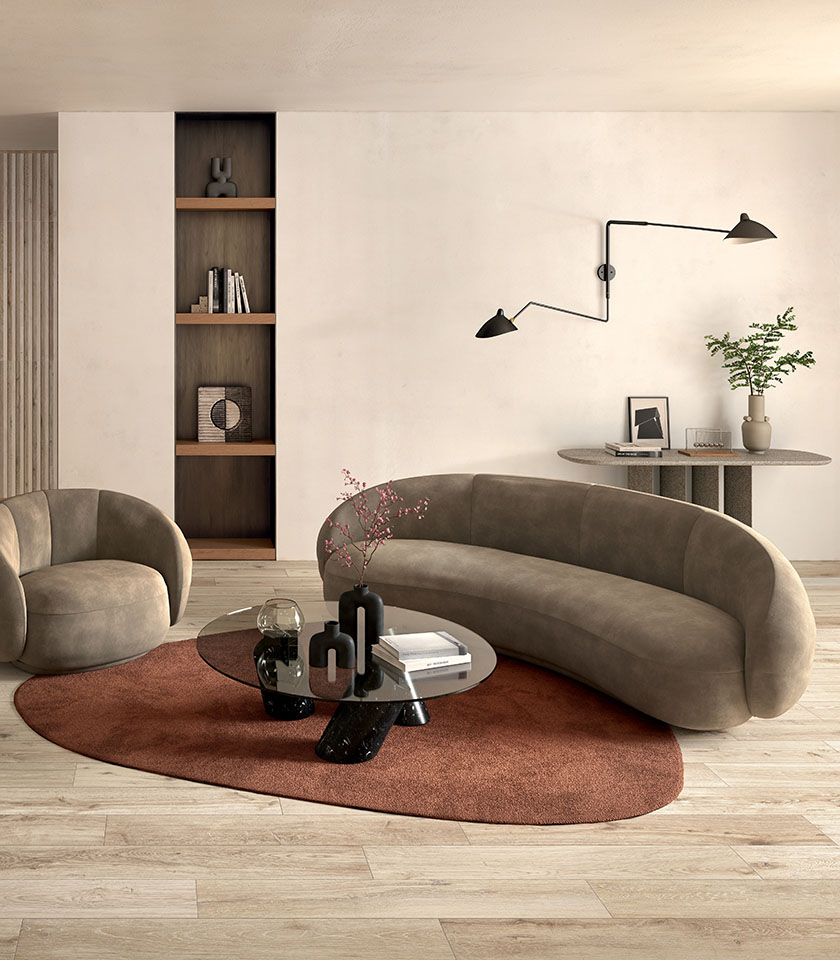 Minimal chic living room with light wood-effect flooring, a softly curved sofa, essential furnishings and warm contemporary design details.