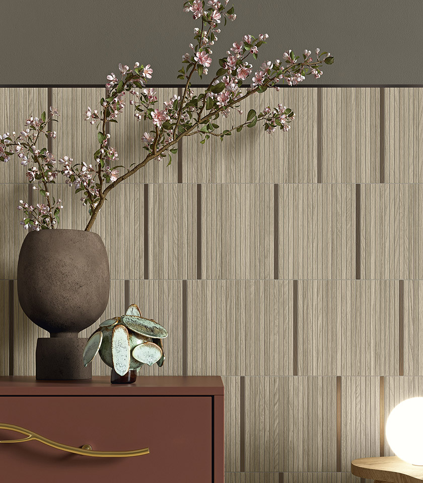 Japandi-style interior with wood-effect wall tiles, a decorative vase with flowering branches and furnishings in natural tones.