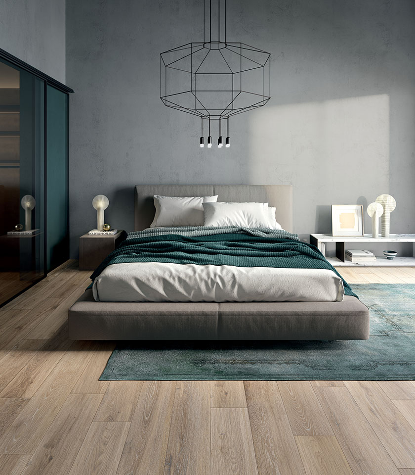 Japandi-style bedroom with wood-effect porcelain stoneware flooring, low bed, minimalist furnishings and neutral tones.