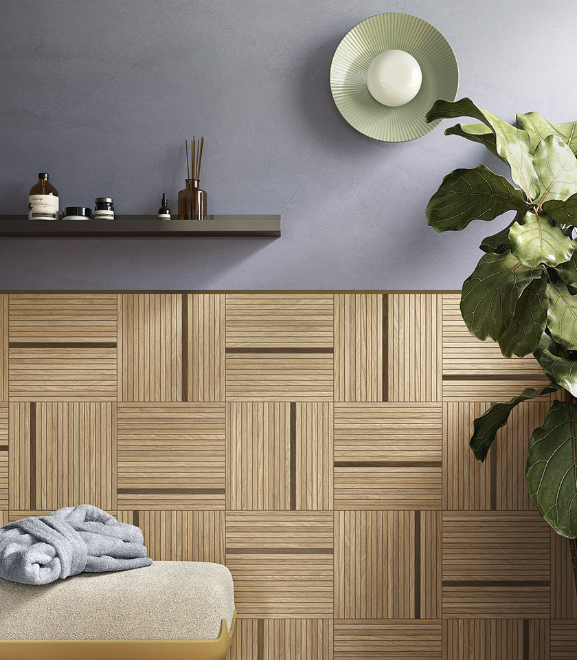 Contemporary bathroom with geometric wood-effect wall tiles, a grey wall and a large green plant.